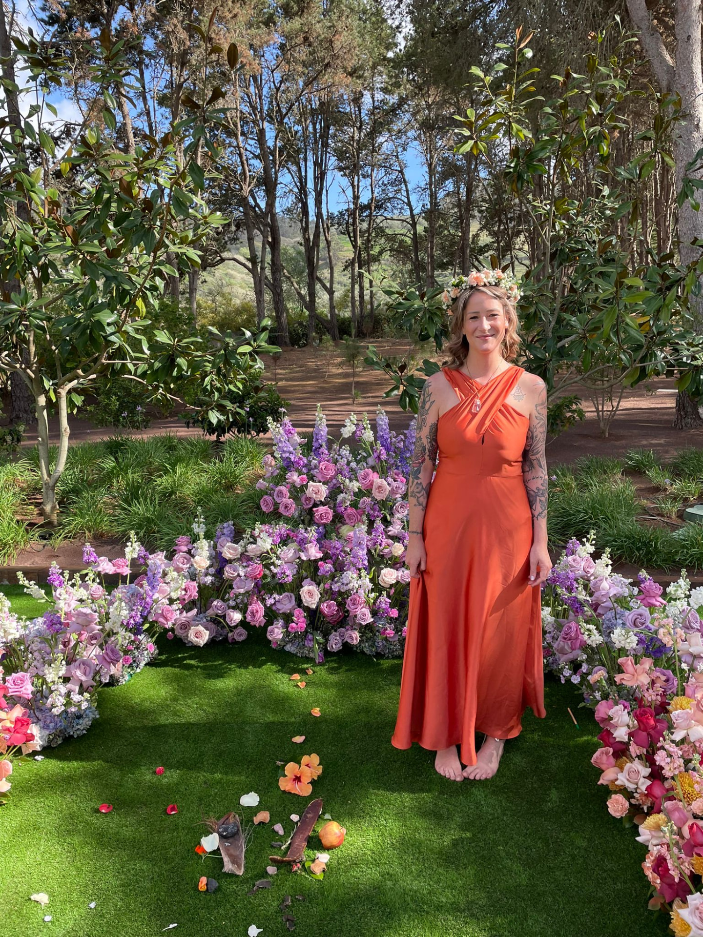 Gisèle Ladner, freie Traurednerin, im orangen Kleid vor einem bunten Blumenmeer